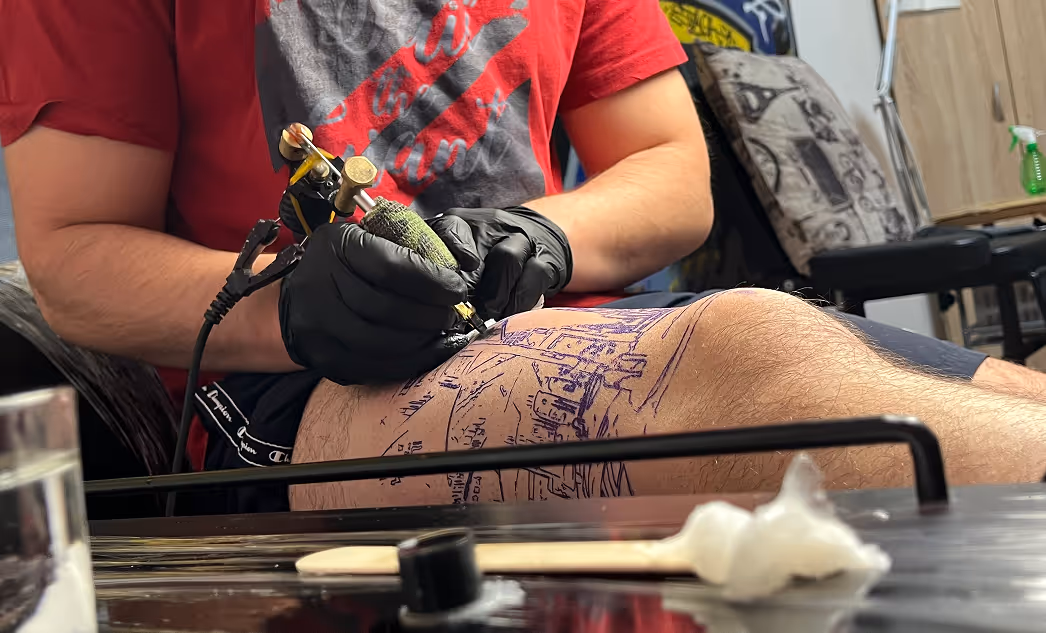 čovek se sam tetovira na nozi