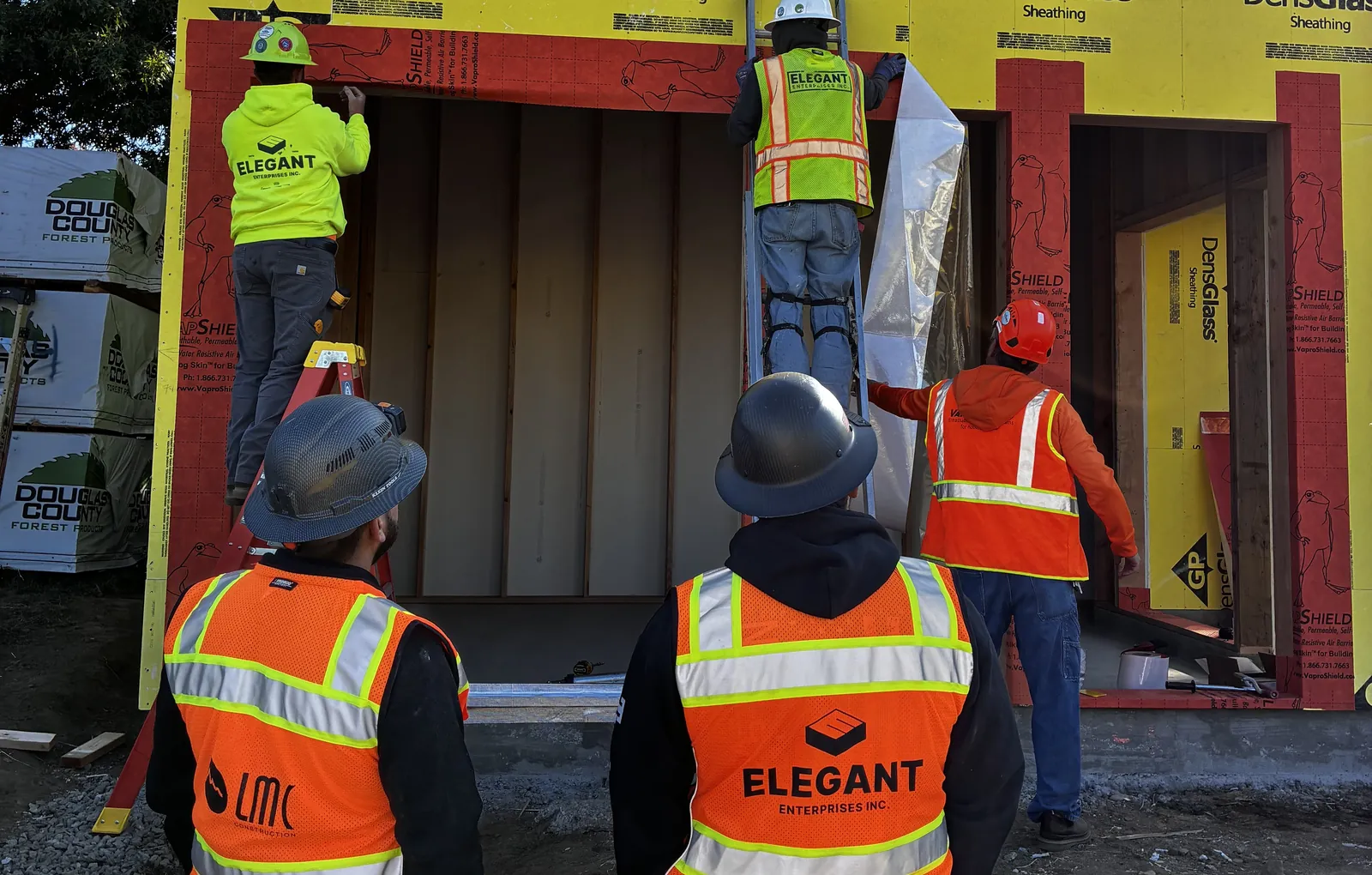 Men working on the exterior of a mockup construction building