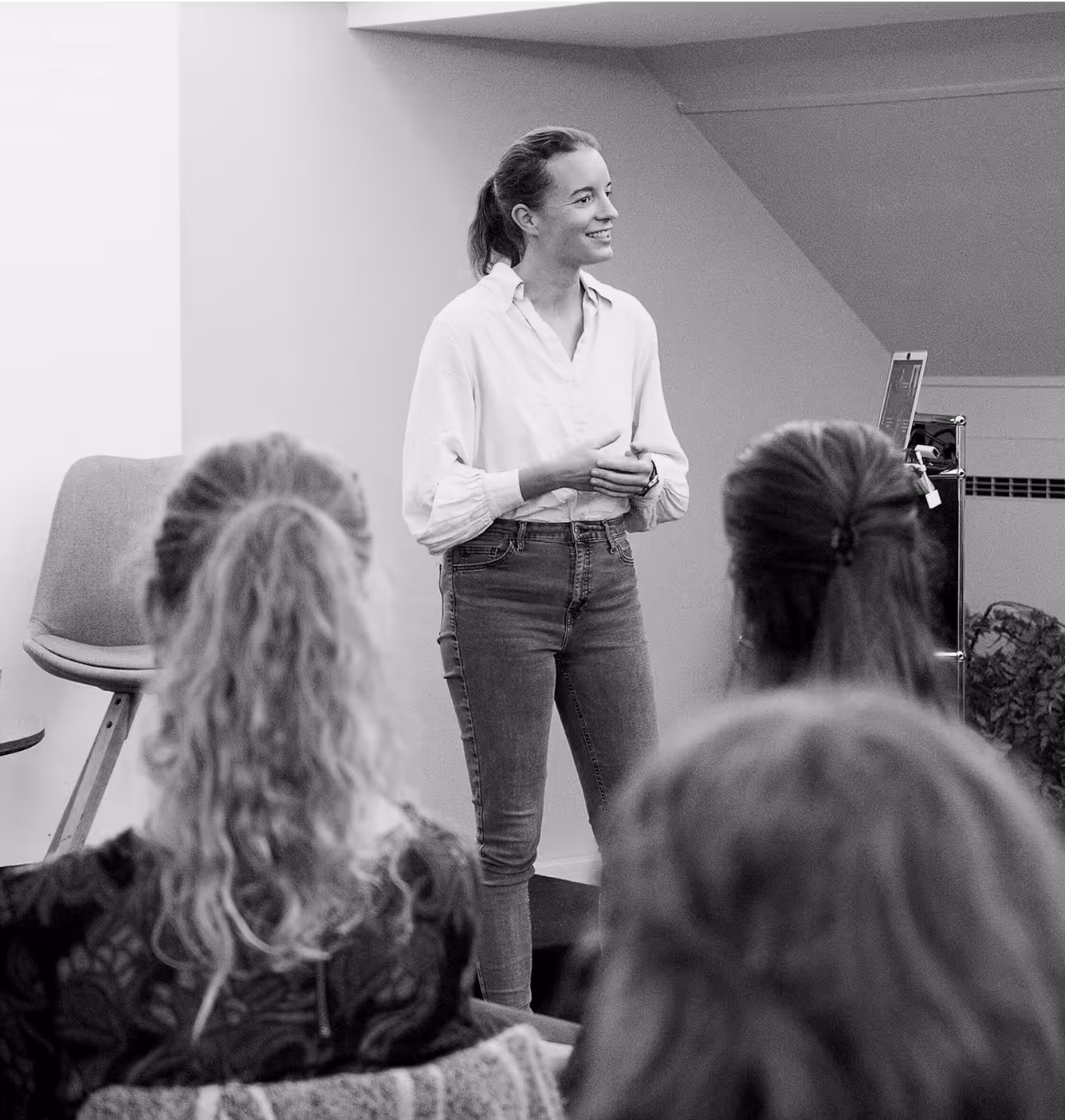 Black and white photo of Lisa Stähli, founder of Hello 50:50 World, smiling while speaking at an event.