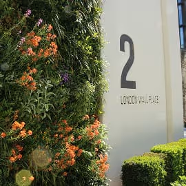 Living wall with colourful flowers next to number 2 sign at 2 London place