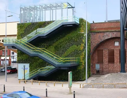 Living wall with green staircase attached to urban brick building exterior