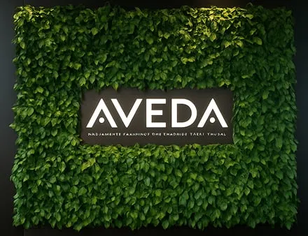 Aveda logo on a lush, living green wall of vibrant leaves