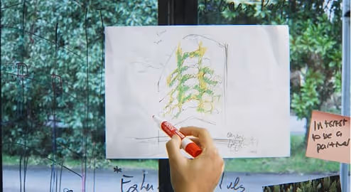 Living wall sketch with green vines drawn on white paper near window
