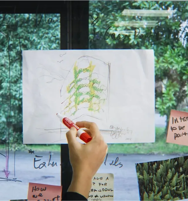 Living wall sketch with green plants drawn on white paper near window