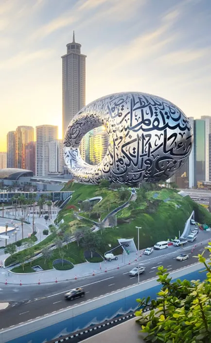 Museum of the future building with living walls at the base with Dubai skyline in the background