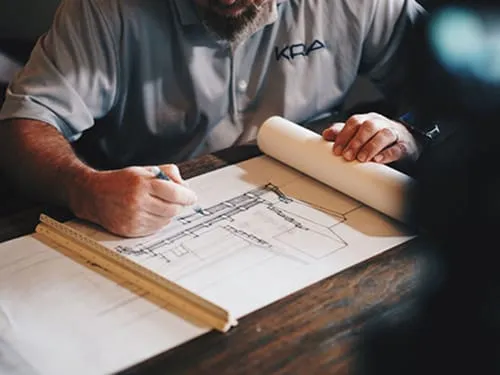 Architect working on living wall design blueprint with ruler and pen
