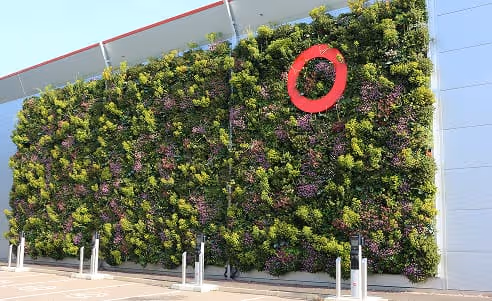 Lush living wall with green and purple plants and SEGRO logo