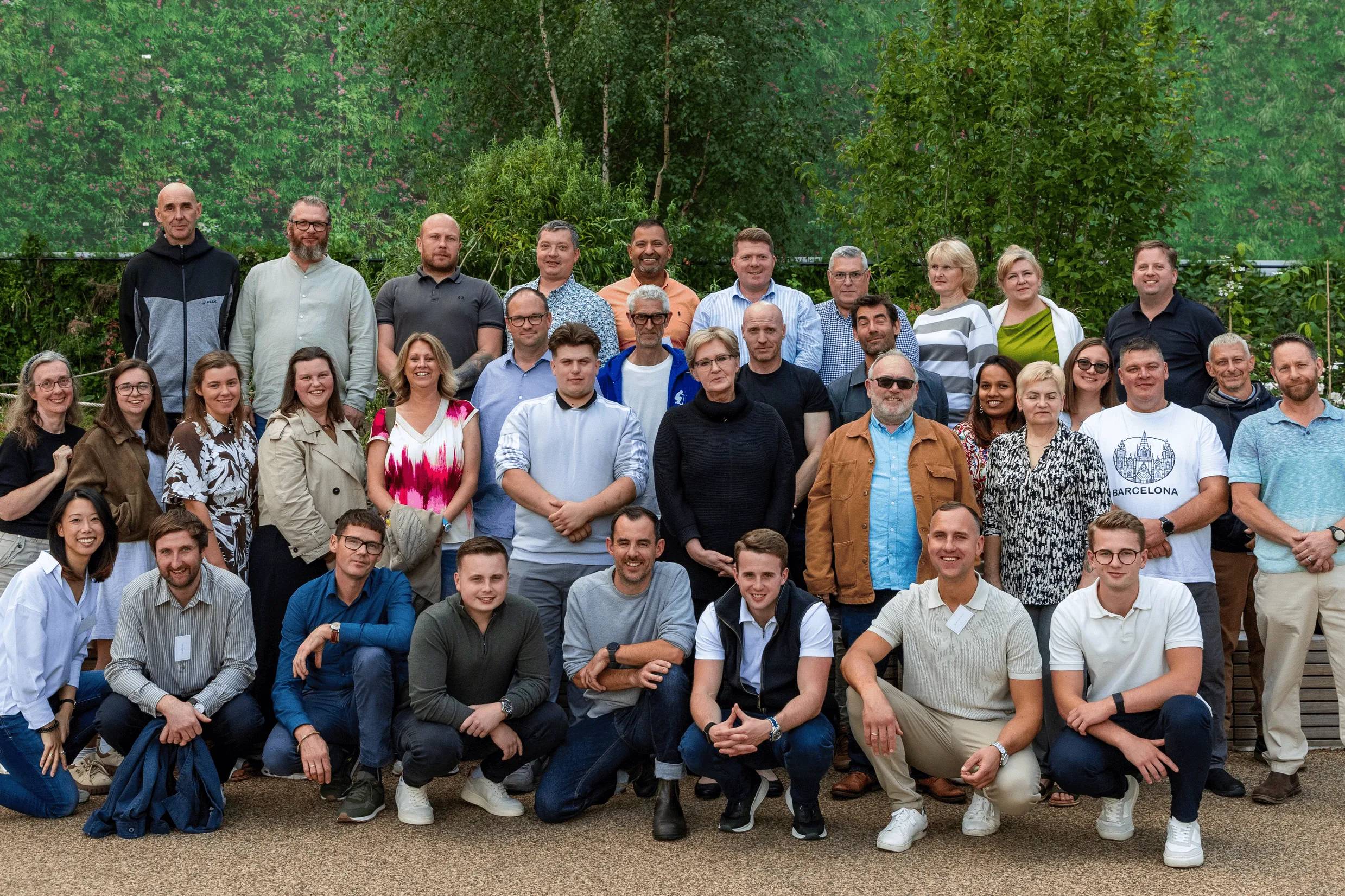 Group of Viritopia employees posing together on a living wall backdrop