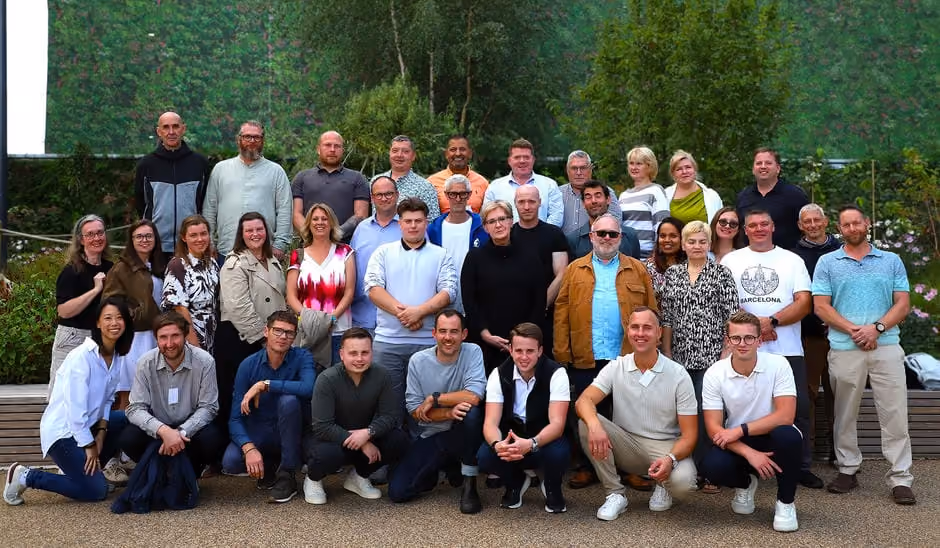 Group of Viritopia employees posing together on a living wall backdrop