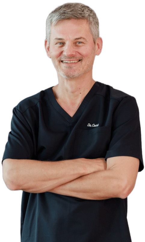 photo of a smiling Dr. Cocris with arms folded across his chest