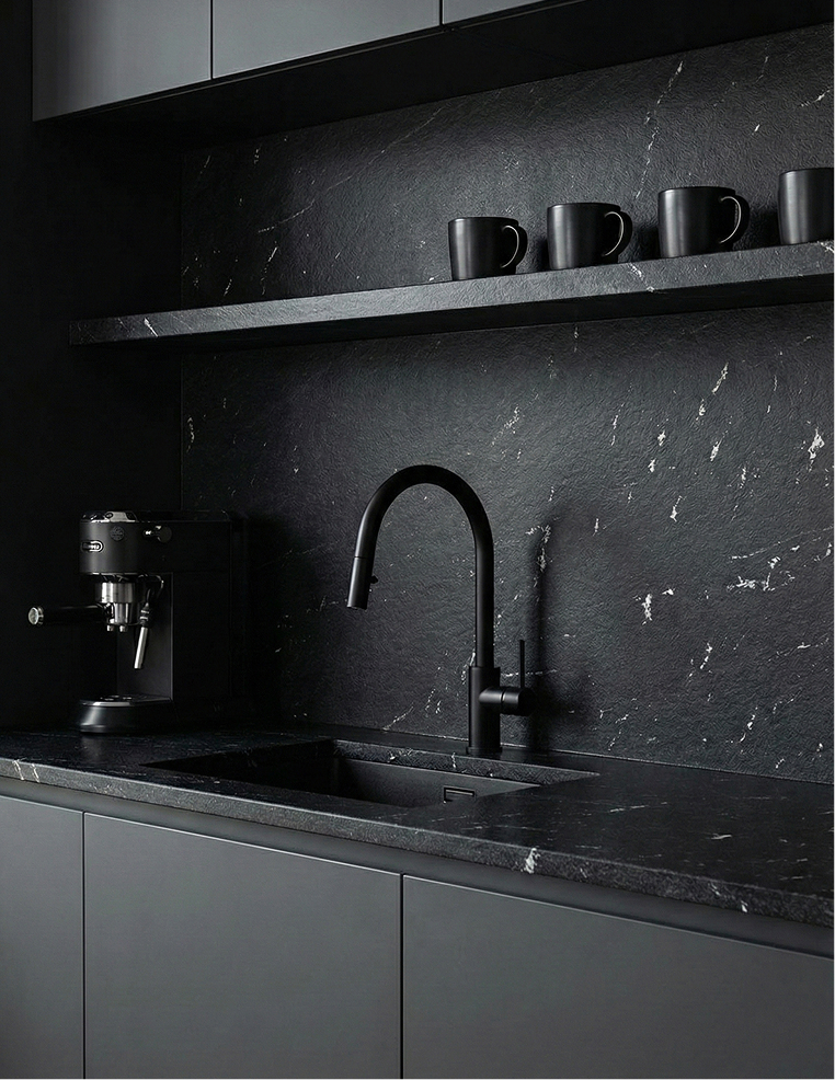 Granito para cocina de color negro con blanco en una encimera moderna, equipada con grifo monomando y cafetera espresso