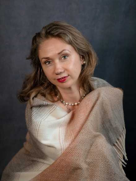 A picture of Yulia holding a scar around her. Photo is from a professional photo studio