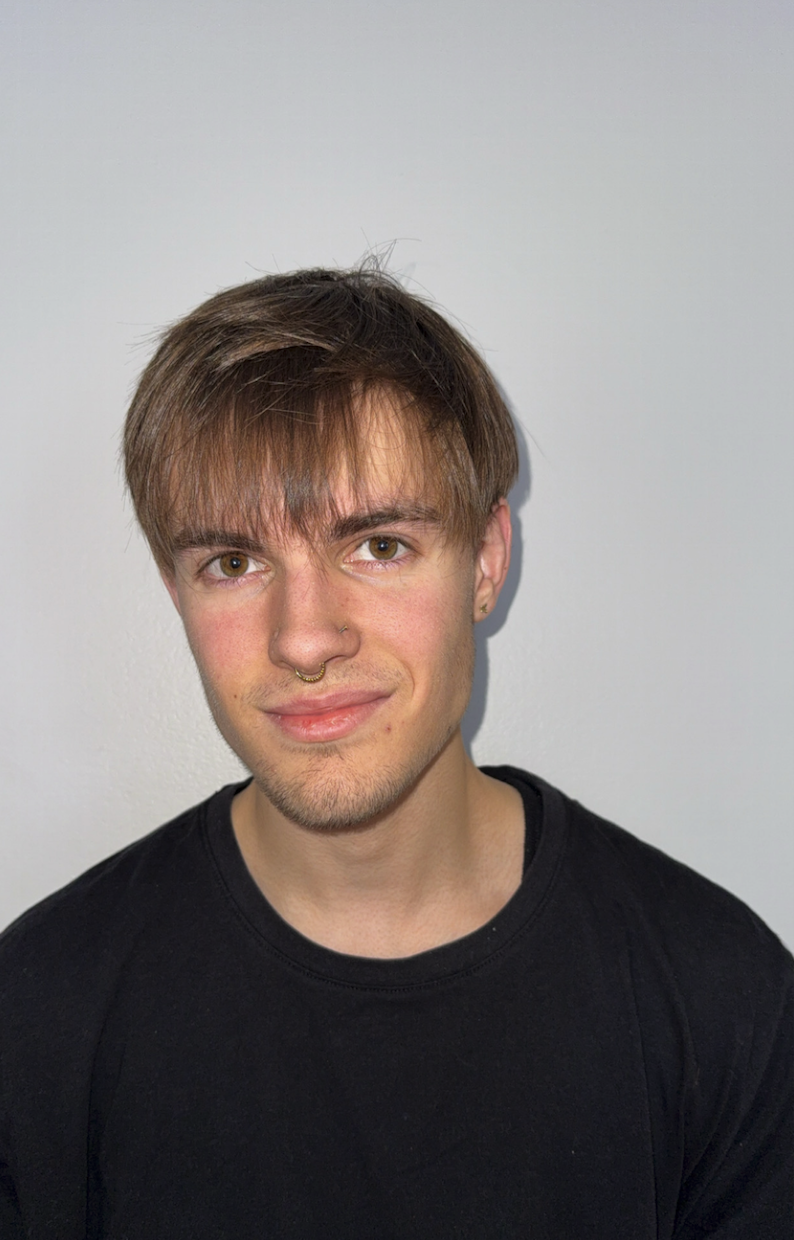 A photo of Cody smiling and wearing a black t-shirt