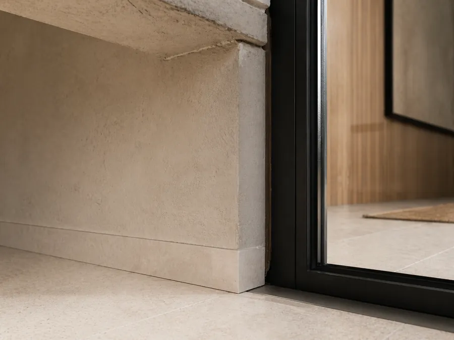 Timber, stone and glass interior with acoustic balance, soft furnishings and warm architectural materials.