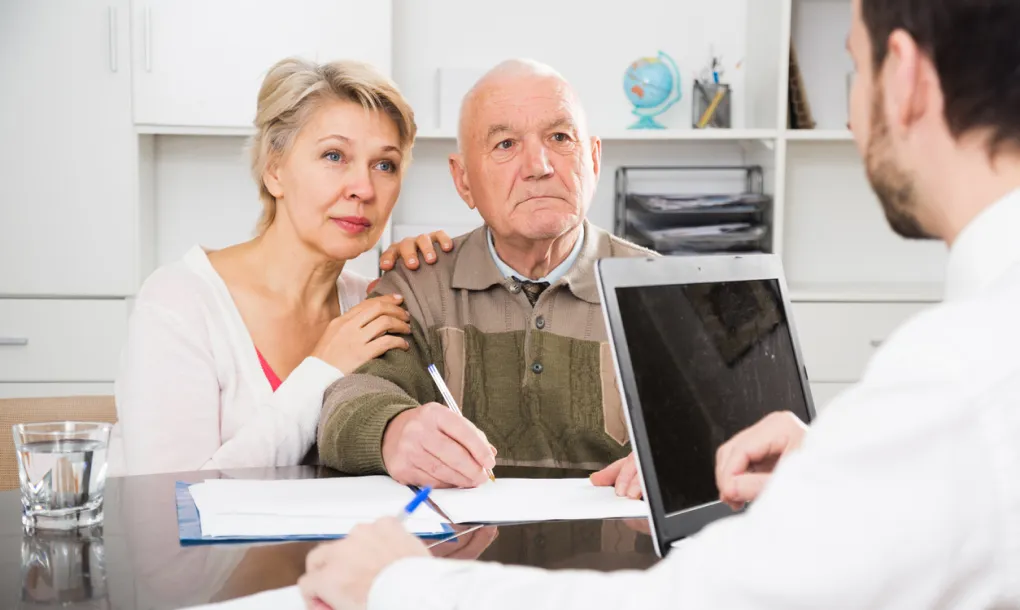 An elderly couple meeting with an advisor discussing assets protection for beneficiaries