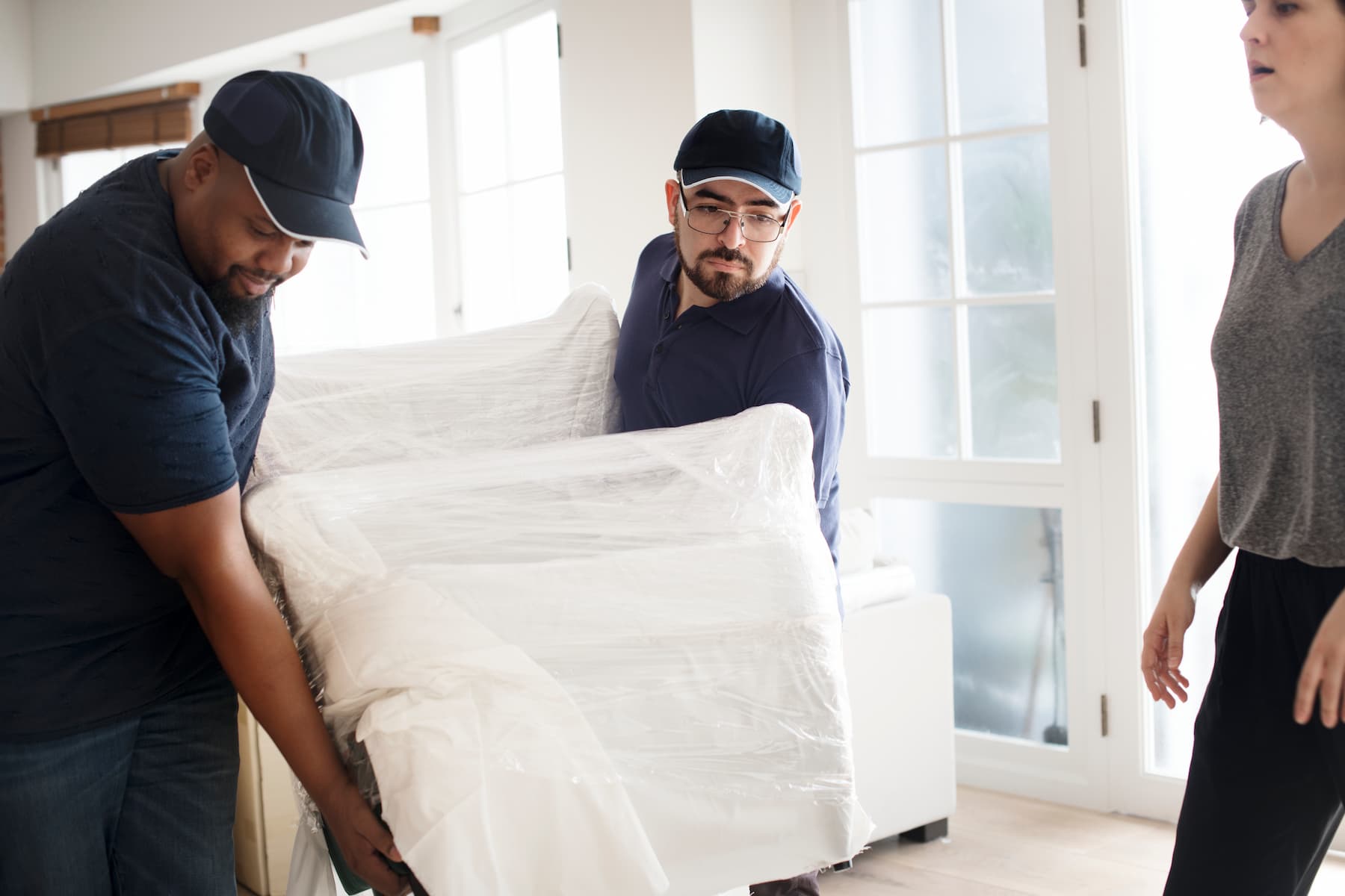 three men moving furniture into moving van