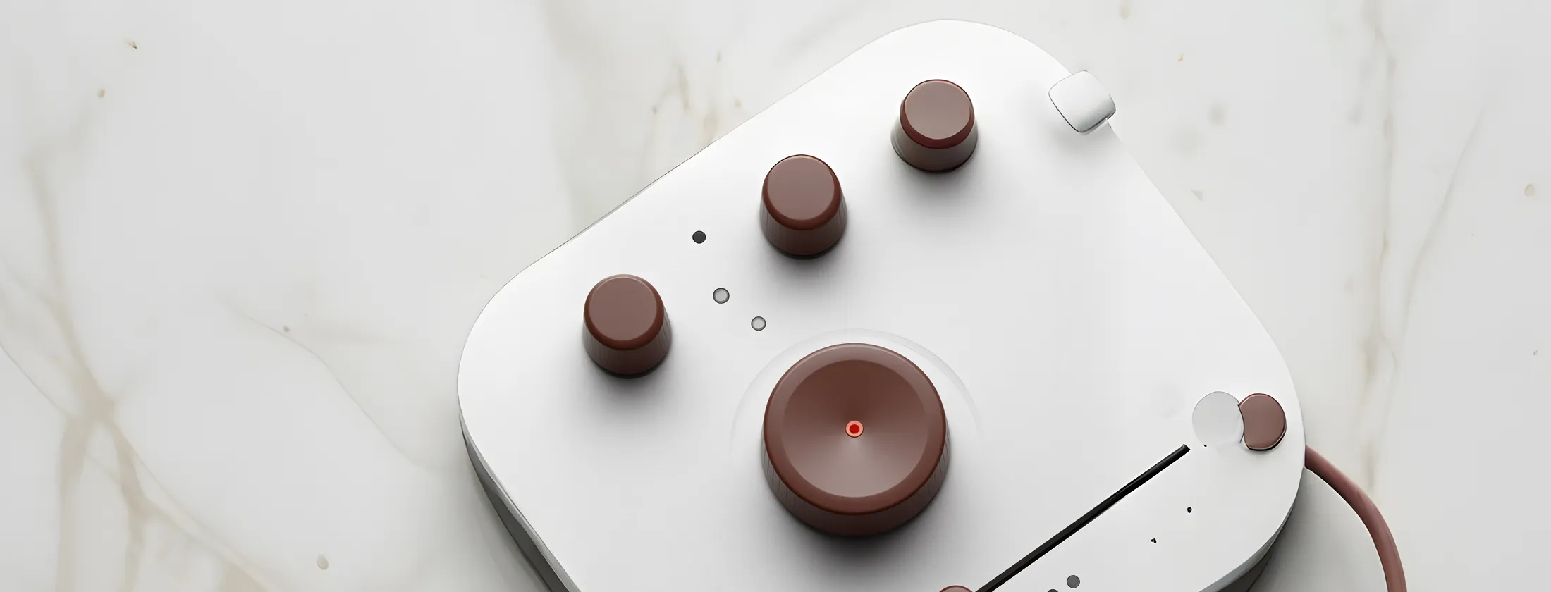 A white and brown gaming controller rests on a polished marble surface, showcasing its sleek design and colors.