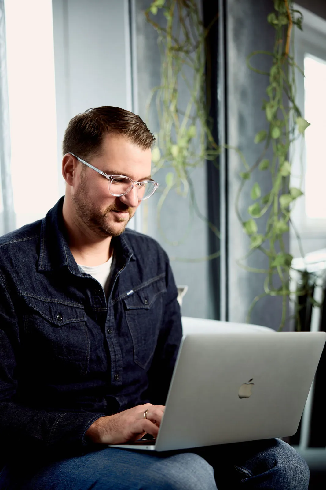 Philip Fuchslocher sitzt und lächelt, während er in den Laptop tippt