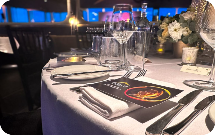 A table is set with silverware and wine glasses.