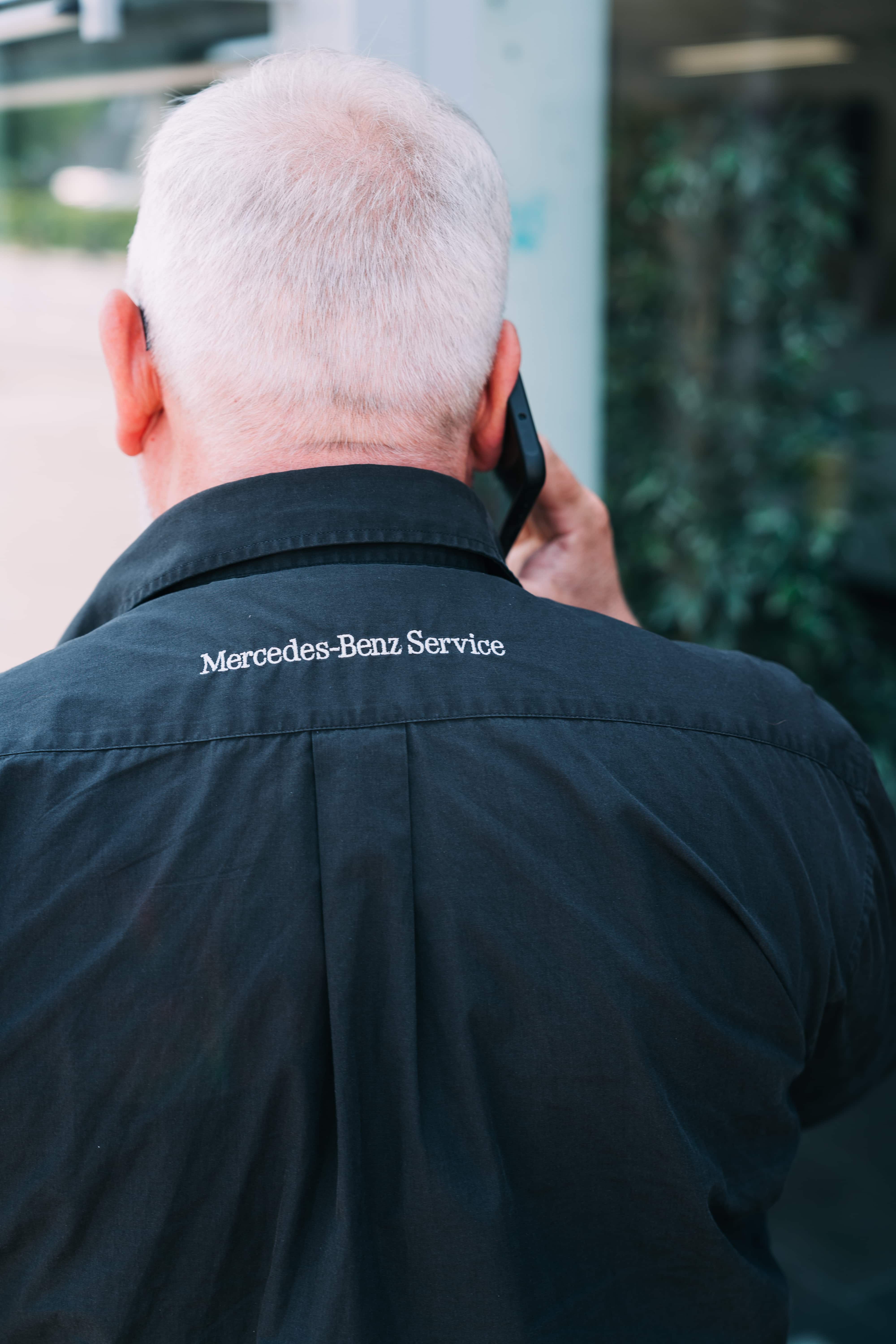 Mitarbeiter im Mercedes-Benz Service Hemd beim Telefonieren