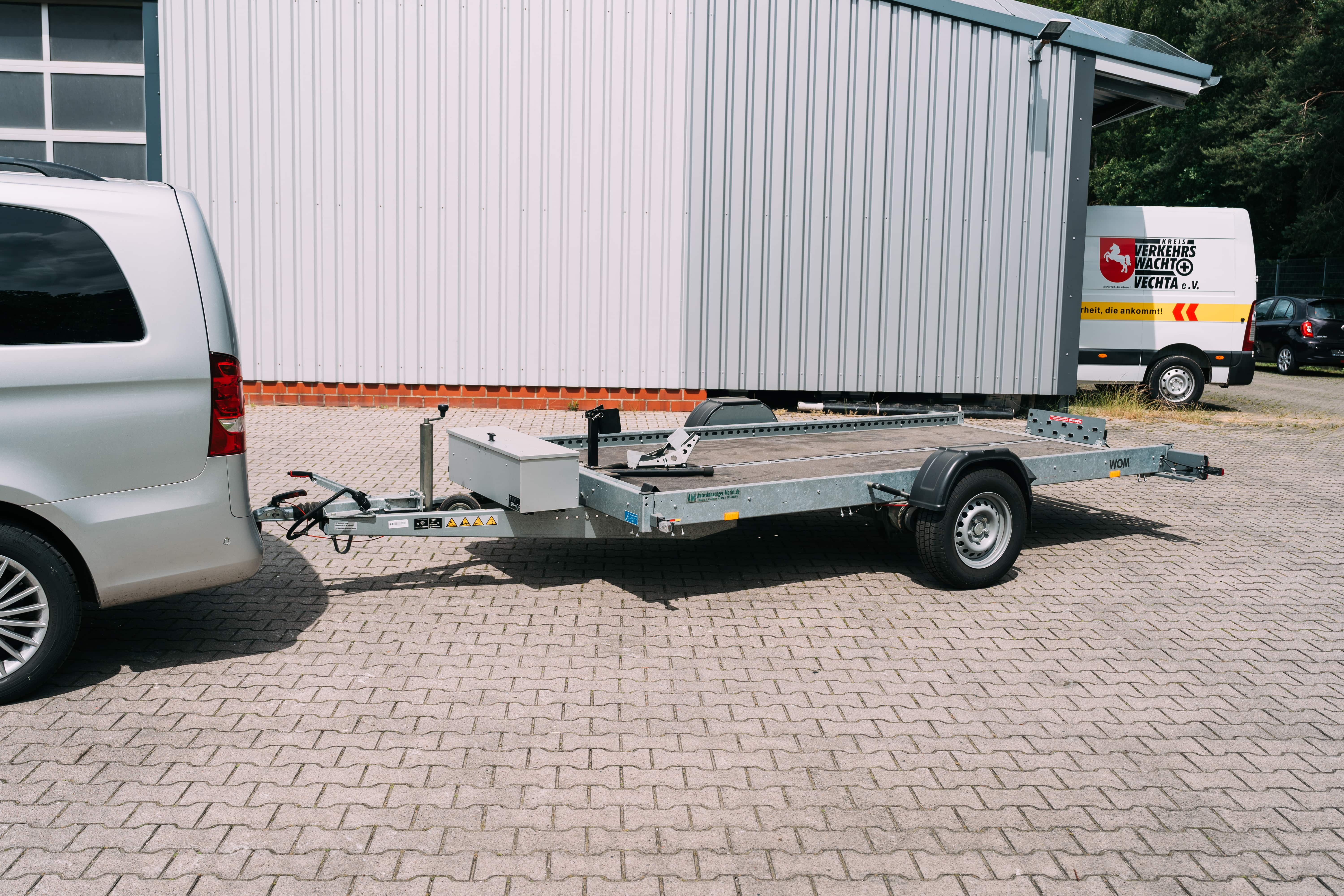 Autotransportanhänger an einem Mercedes-Benz Van auf dem Hof von Autohaus Meyer