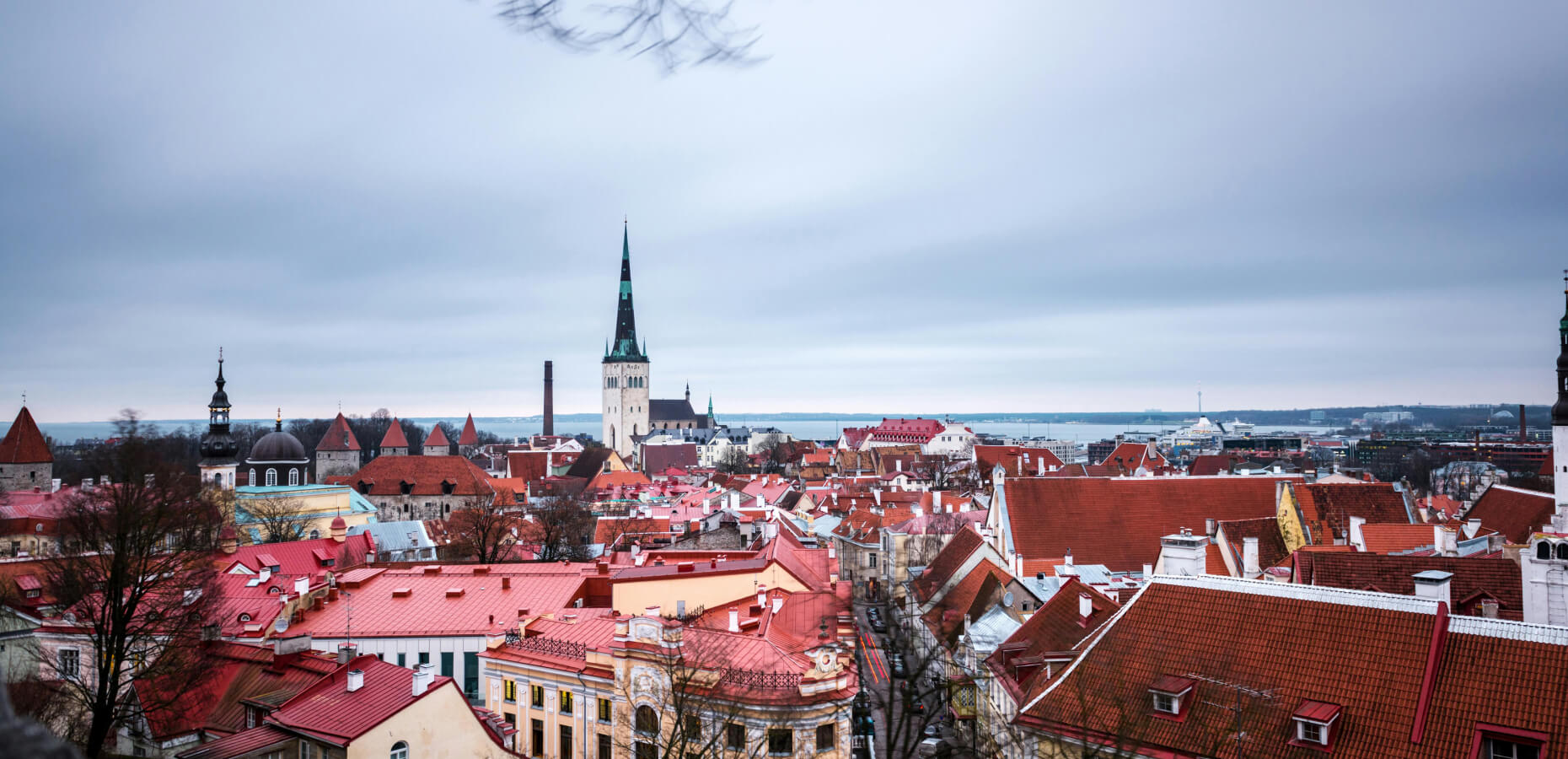A panoramic view of Tallinn cityscape, showcasing various architectural styles under an overcast sky.