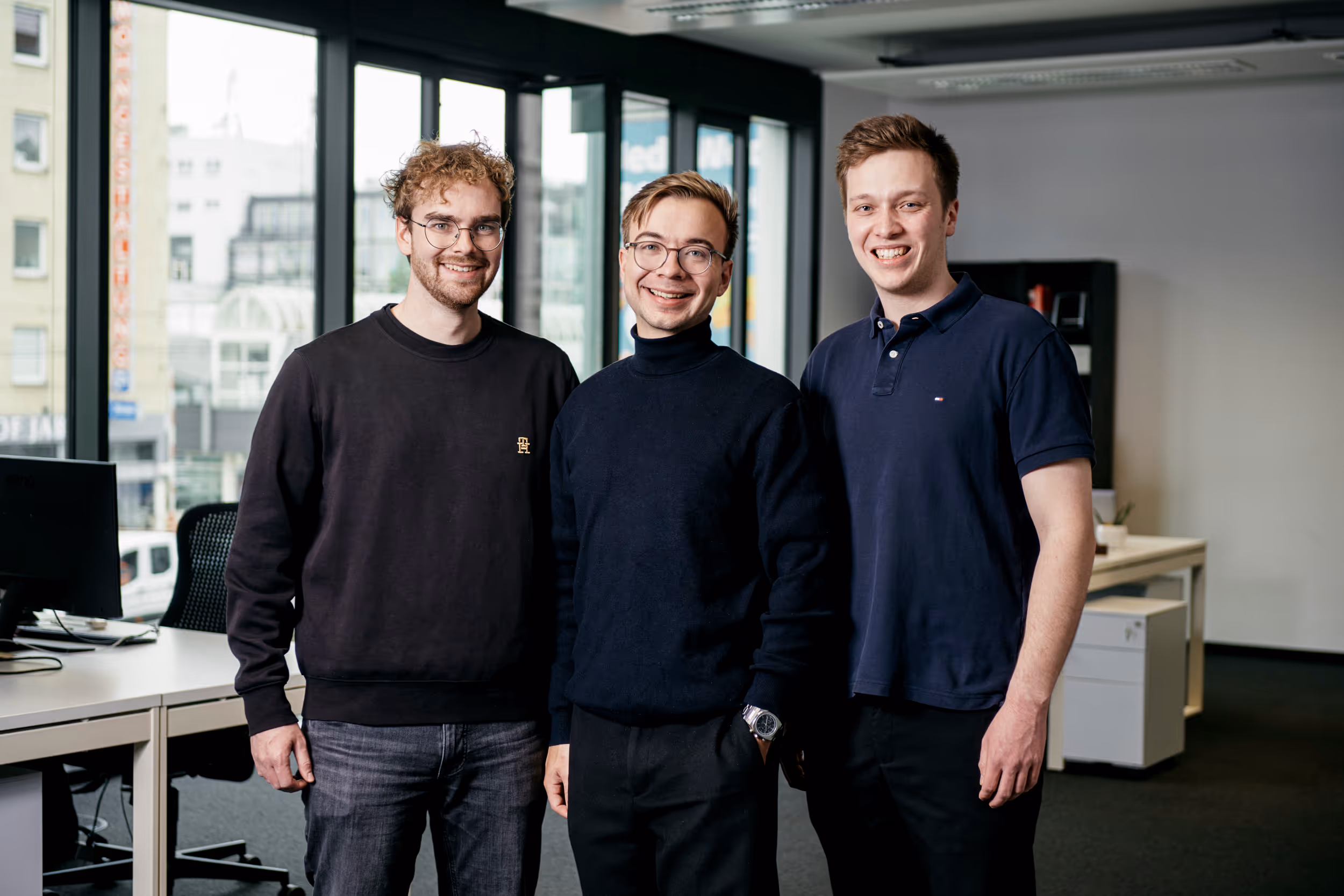 Gruppenbild von drei jungen Männern in einem Büro