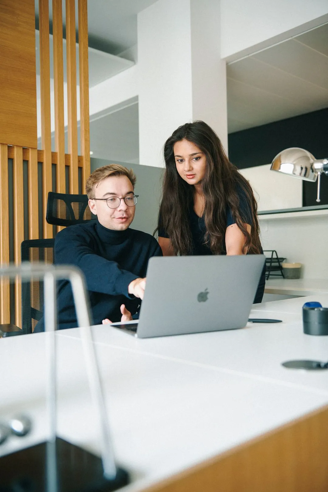 Ein Mann und eine Frau schauen auf einen Laptop