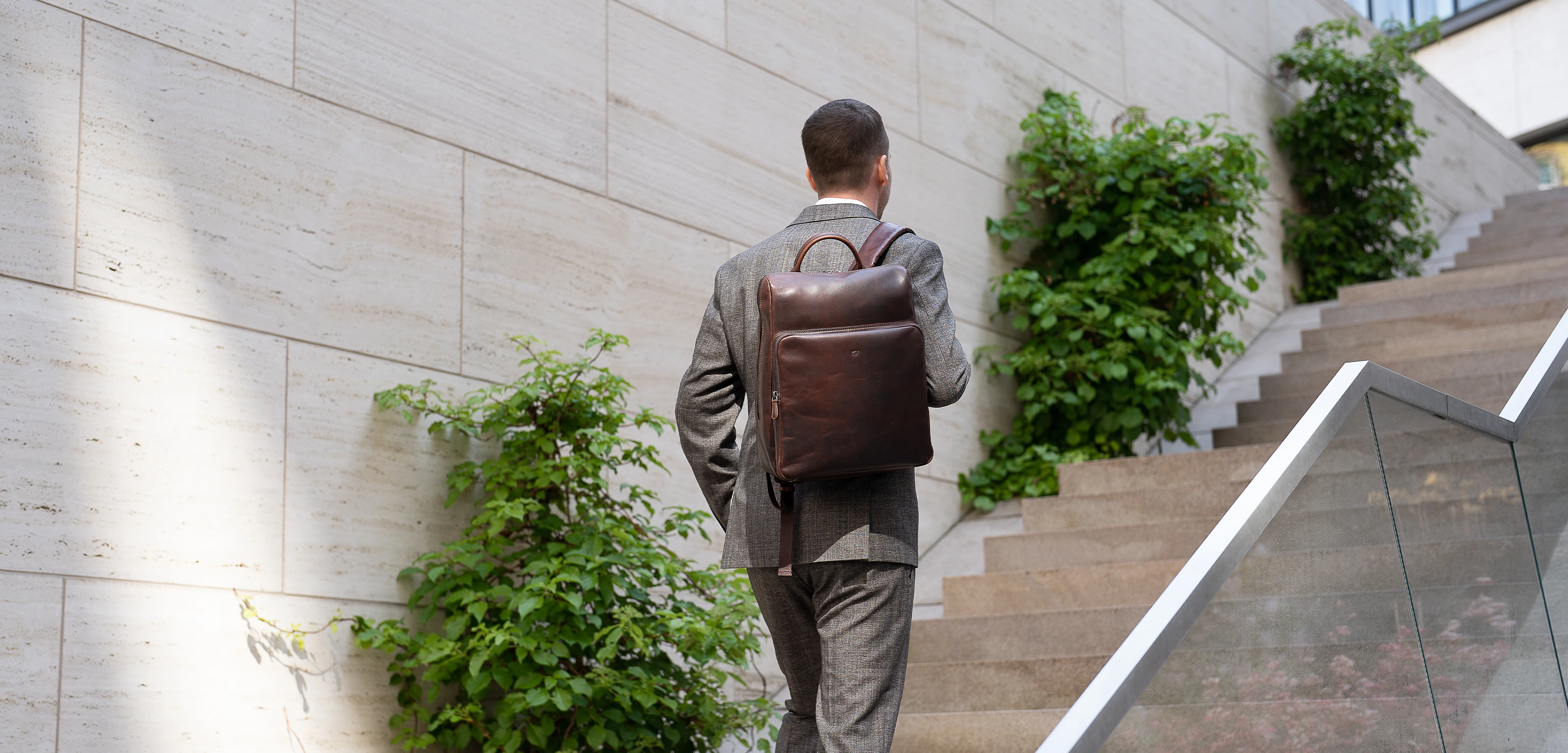 Mann auf einer Treppe mit Lederrucksack