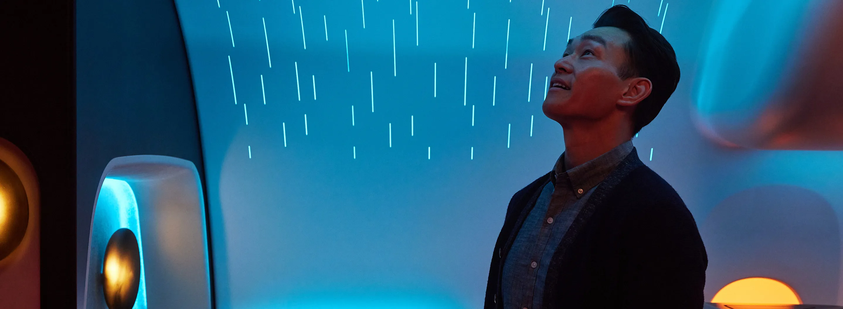 A man standing in front of a blue light.
