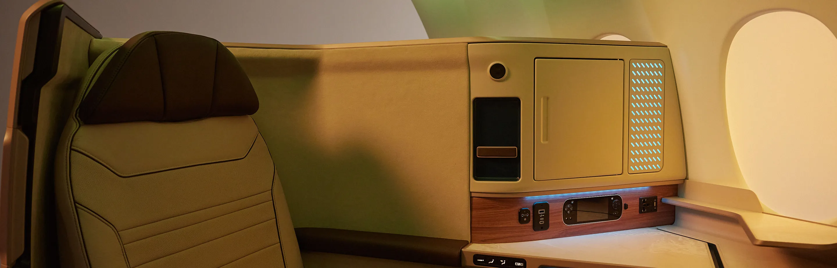 The interior of an airplane with a computer on the desk.