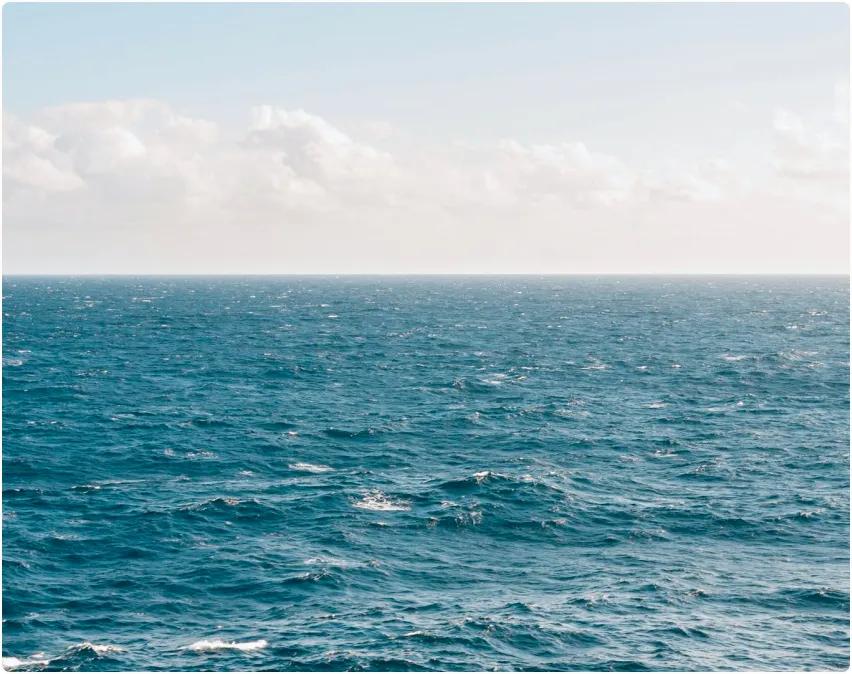 A large body of water sitting under a cloudy sky.