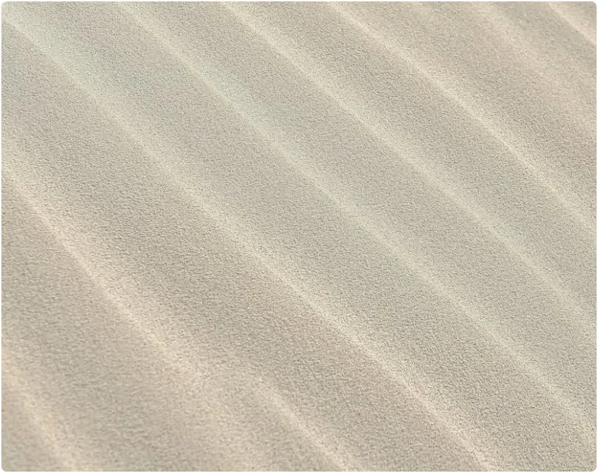 A close up of a sandy beach with waves.