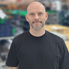 A man with a bald head wearing a black shirt.