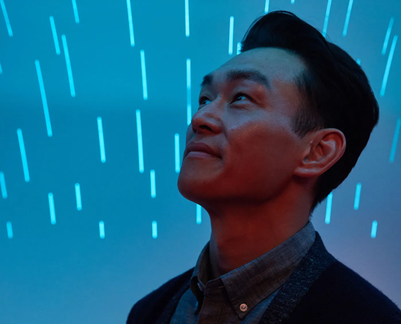 A man standing in front of a blue background.