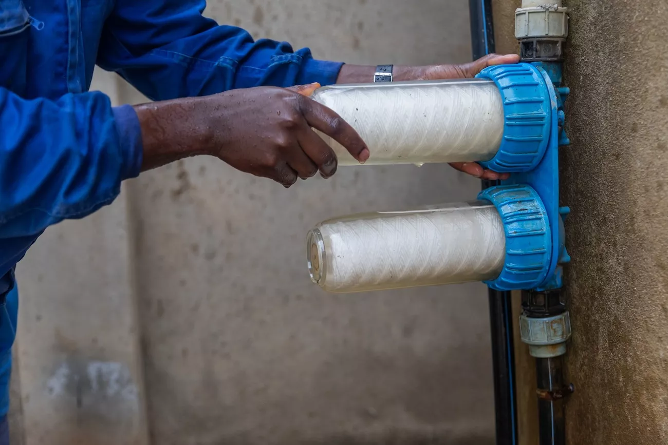 Water engineer changing the filters on a water filtration system.