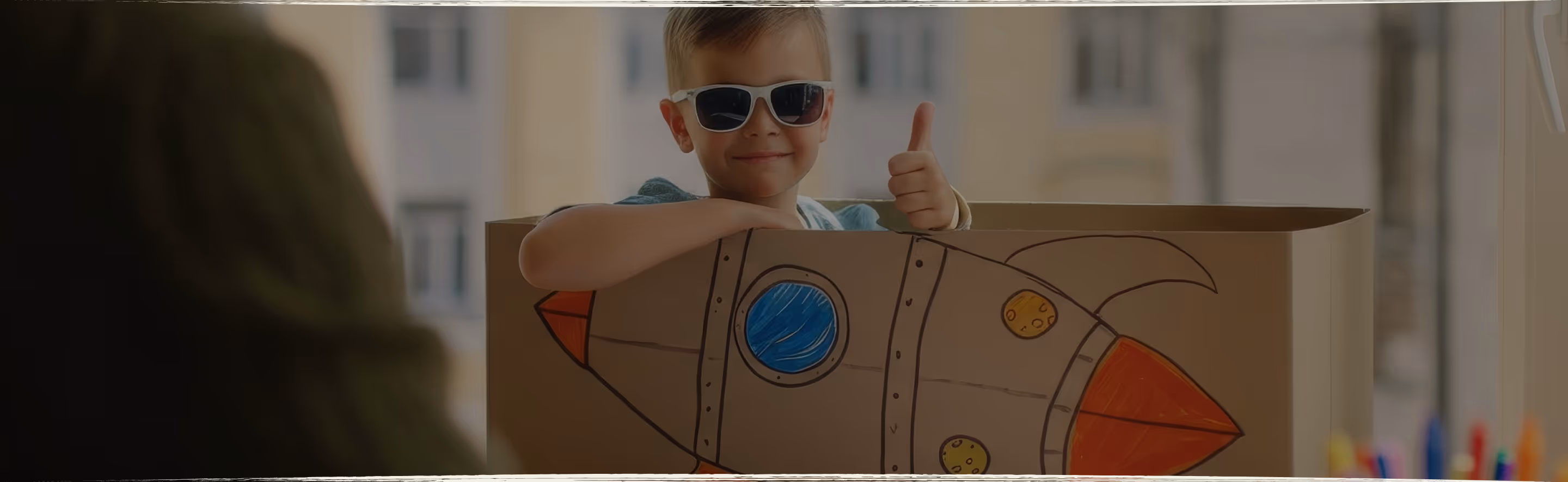 A young child lying on the floor focused on arranging colorful therapeutic stickers, demonstrating concentrated play-based learning activities
