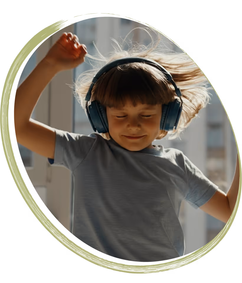 Boy wearing large headphones, raising his hand while listening to music.