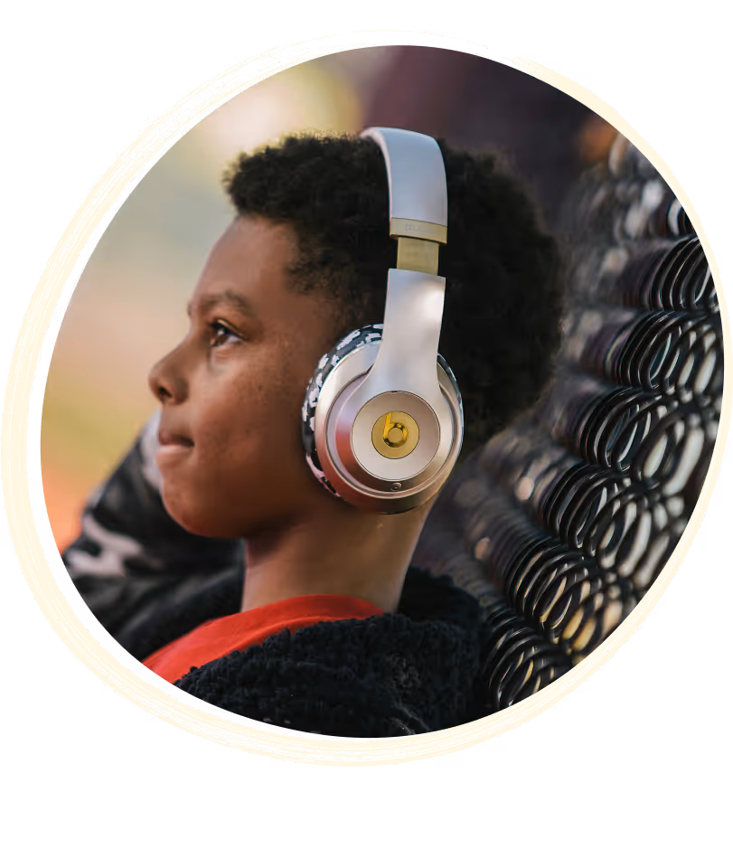 Boy with colorful headphones, sitting and looking forward with focus.