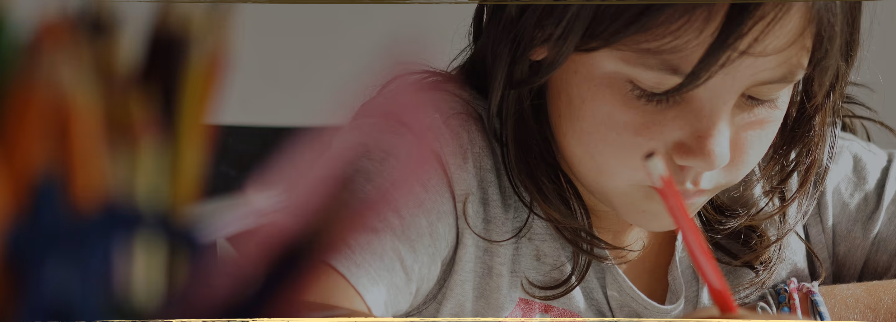 A young child lying on the floor focused on arranging colorful therapeutic stickers, demonstrating concentrated play-based learning activities