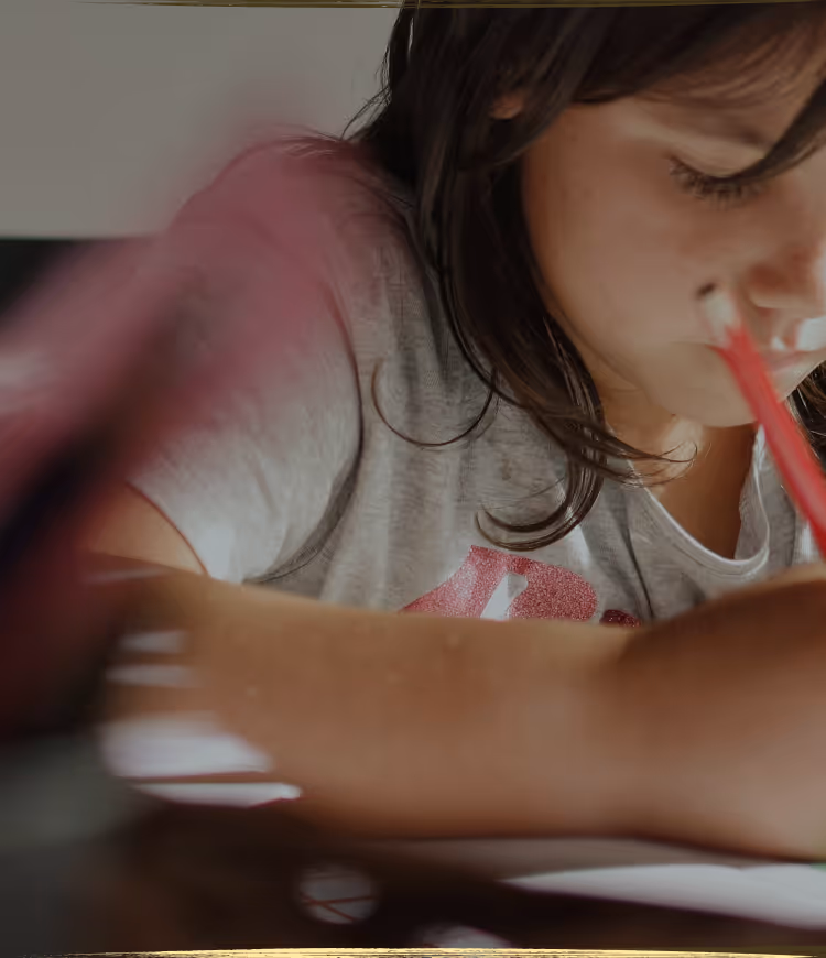 A young child lying on the floor focused on arranging colorful therapeutic stickers, demonstrating concentrated play-based learning activities