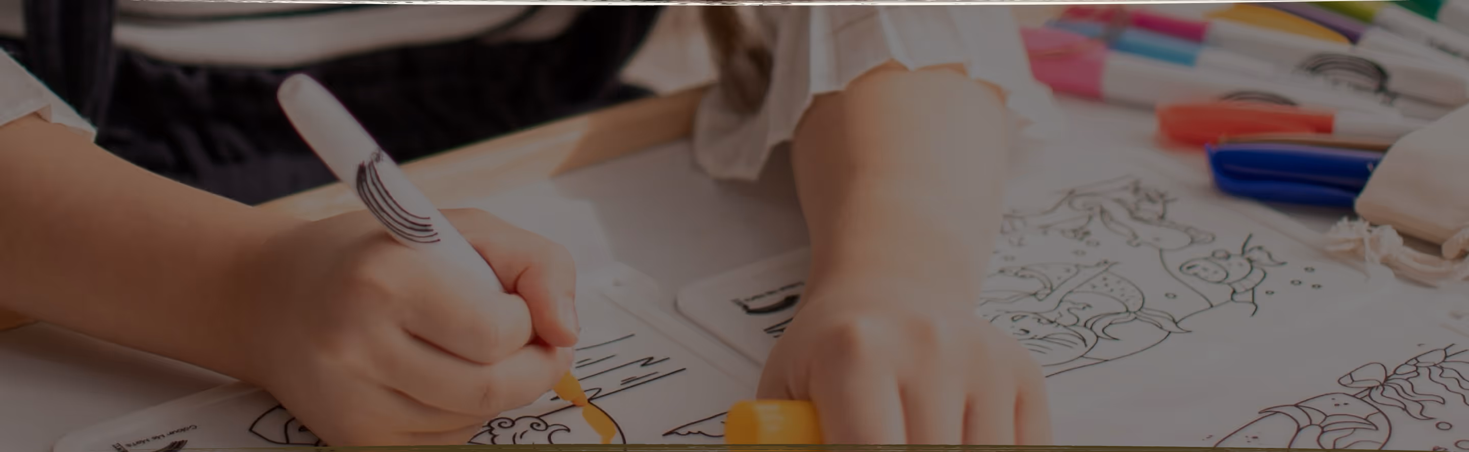 A young child lying on the floor focused on arranging colorful therapeutic stickers, demonstrating concentrated play-based learning activities