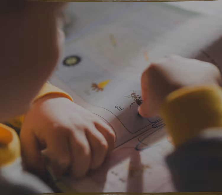 A young child lying on the floor focused on arranging colorful therapeutic stickers, demonstrating concentrated play-based learning activities