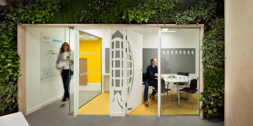 Interior of the Green Building Council office, showing a living wall feature around glass doors