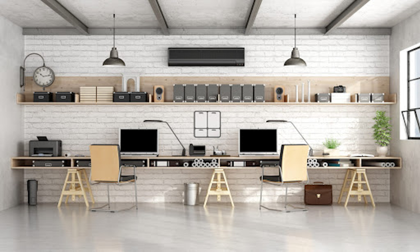 Minimalist workspace with computers, shelves, and white brick wall