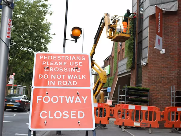 The construction of a living wall with a cherry picker in Walthamstow. "Footway closed" sign in the foreground.