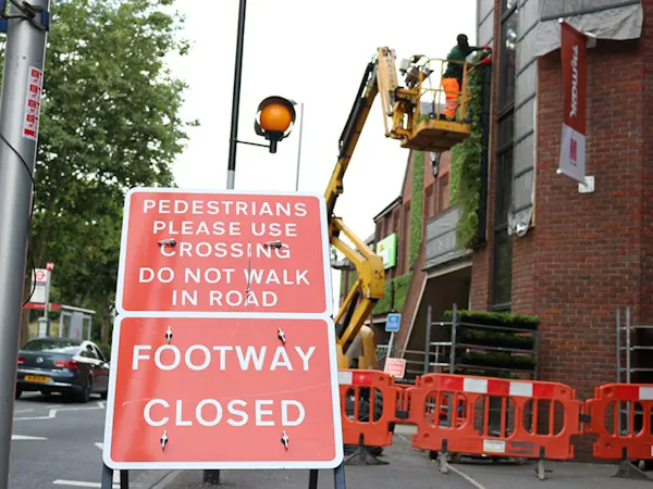 The construction of a living wall with a cherry picker in Walthamstow. "Footway closed" sign in the foreground.