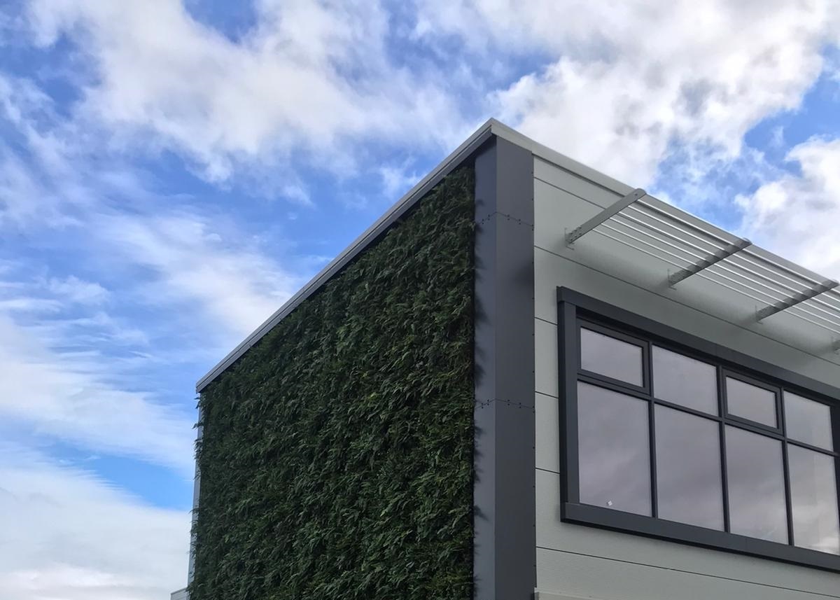 Modern building with living wall against blue cloudy sky