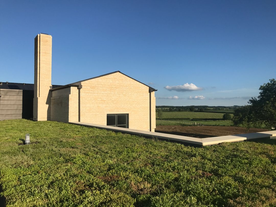 Modern living wall building with green roof overlooking rural landscape