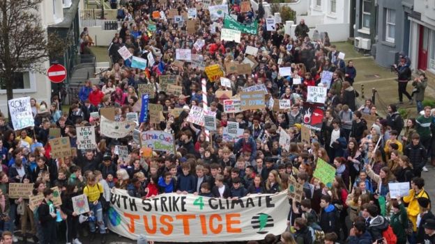 youth protesters demanding climate justice on city street